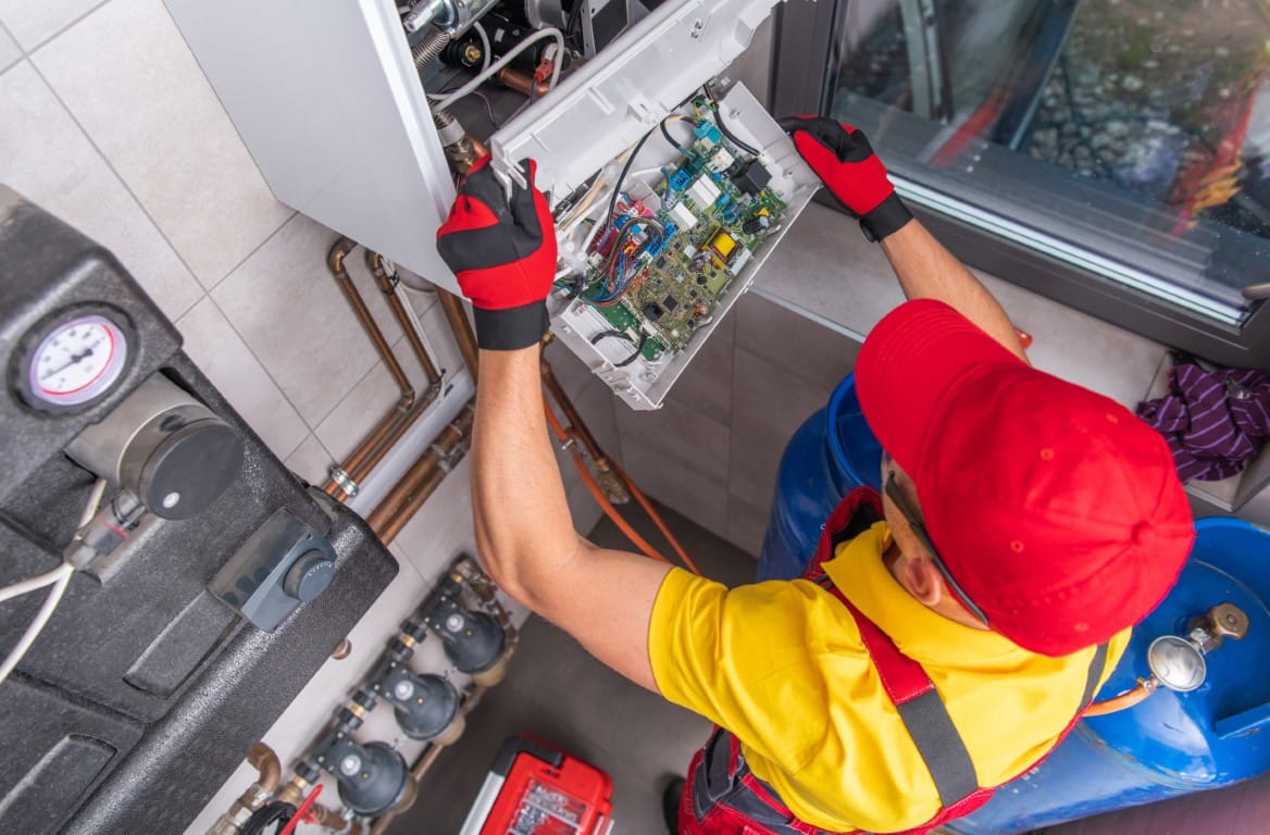 Professional plumber performing gas heater repair