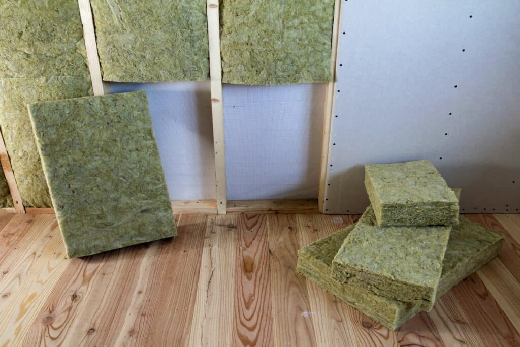 Wooden frame for future walls with drywall plates insulated with rock wool and fiberglass insulation staff for cold barrier. Comfortable warm home, economy, construction and renovation concept.